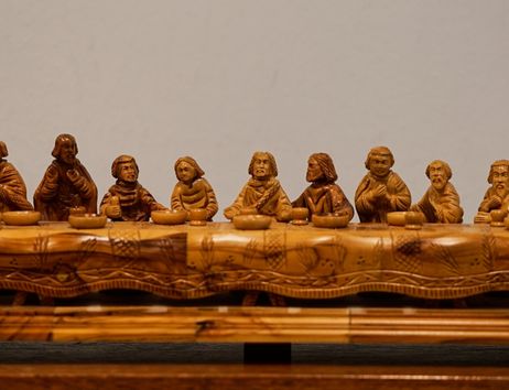 Detail aus der Adventskirche der Kirchengemeinde Hamburg-Schnelsen: geschnitzte Figuren an einem langen Tisch, vermutlich ein Abendmahlsmotiv.