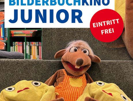 Plakat für das Bilderbuchkino Junior in der Stadtbücherei Norderstedt mit einem Stofftier und gelben Kissen.