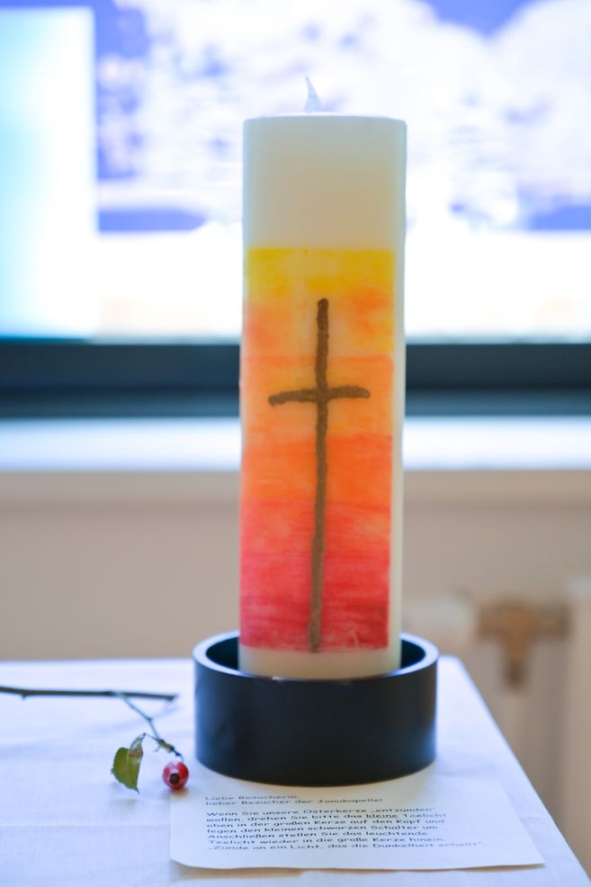 Kerze mit Kreuzmotiv vor einem hellen Hintergrund beim ökumenischen Gottesdienst im Friedrich-Ebert-Krankenhaus Neumünster.