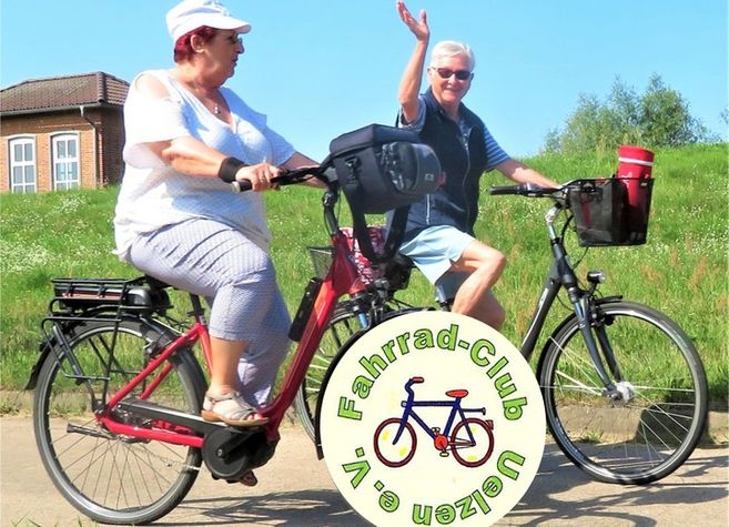 Zwei Personen fahren auf Fahrrädern auf einem Weg, umgeben von grüner Landschaft. Ein Logo des Fahrrad-Clubs Uelzen e.V. ist im Vordergrund sichtbar.