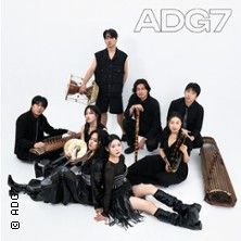 Eine Musikgruppe namens ADG7 posiert in schwarzer Kleidung mit traditionellen Instrumenten.