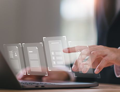 Es sind Hände zu sehen, die auf einem Laptop tippen