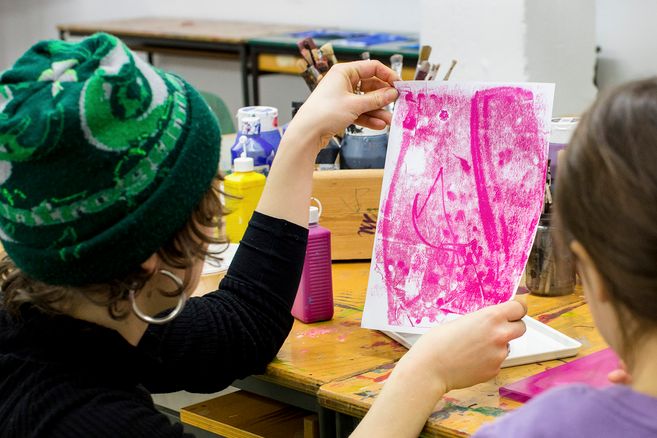 Person hält ein Kunstwerk in einem Workshop hoch.