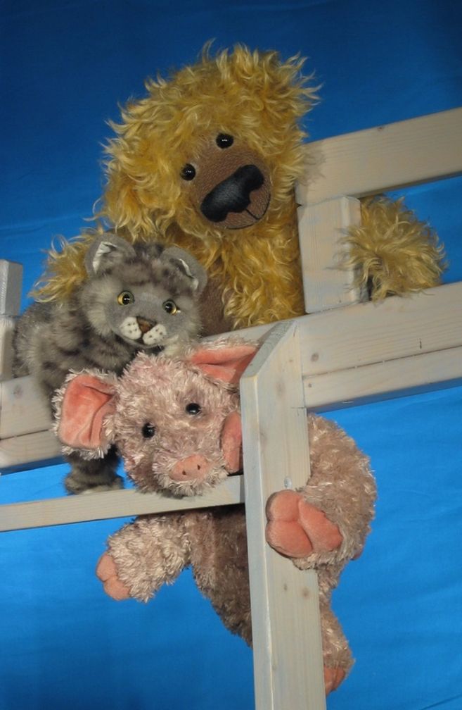 Man sieht den Rand von einem Hochbett, auf dem Kuschelbär-, -katze und -schwein sitzen.