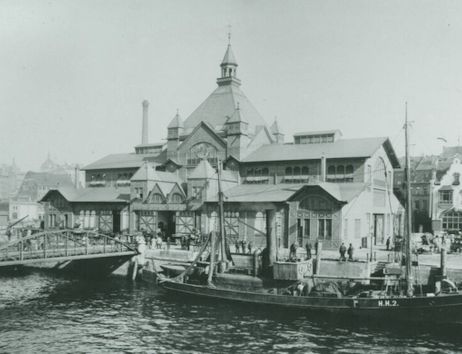 Historisches Foto der Fischauktionshalle in Hamburg mit einem Schiff im Vordergrund.