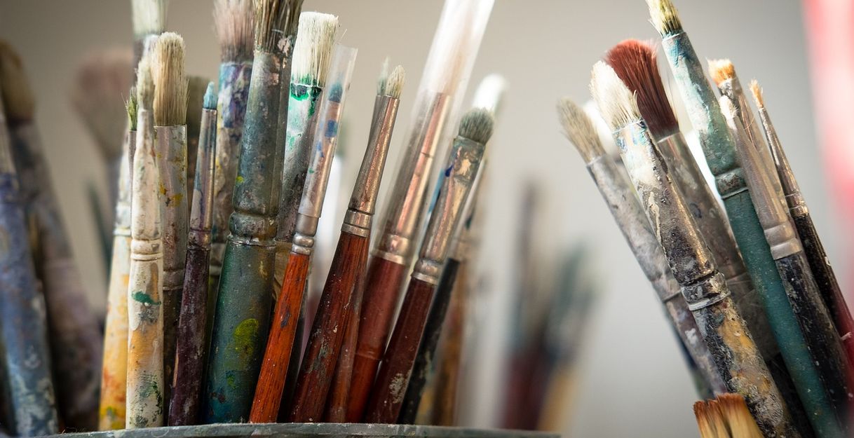 Nahaufnahme von verschiedenen, gebrauchten Pinseln in einem Behälter.