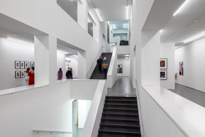 Innenansicht eines modernen Museums mit weißen Wänden und Treppen.