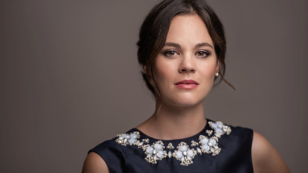 Porträt einer Frau mit dunklem Haar und elegantem Kleid.