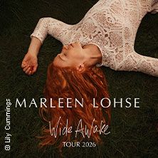 Frau mit roten Haaren liegt in weißem Spitzenkleid auf Gras, Schriftzug 'Marleen Lohse Wide Awake Tour 2026'.