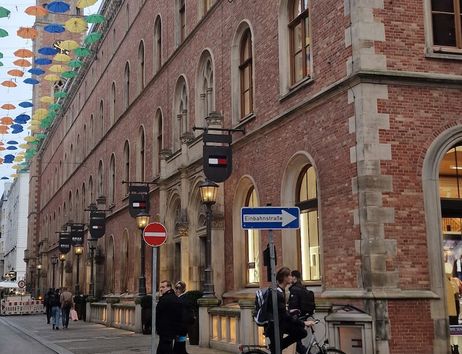 Historisches Gebäude in Hamburg mit bunten Regenschirmen über der Straße.