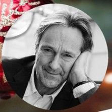 Schwarz-weiß Porträt eines Mannes mit nachdenklichem Ausdruck, der seinen Kopf auf die Hand stützt.