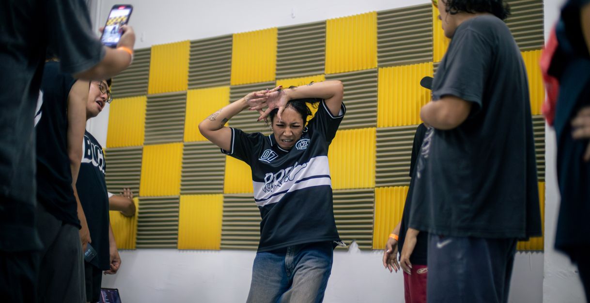 Several dancers in one picture, with a krump dancer dancing in the middle.