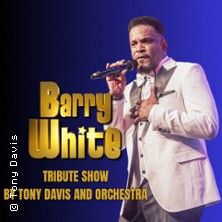 Ein Sänger in einem weißen Anzug hält ein Mikrofon auf einer Bühne. Text: Barry White Tribute Show by Tony Davis and Orchestra.