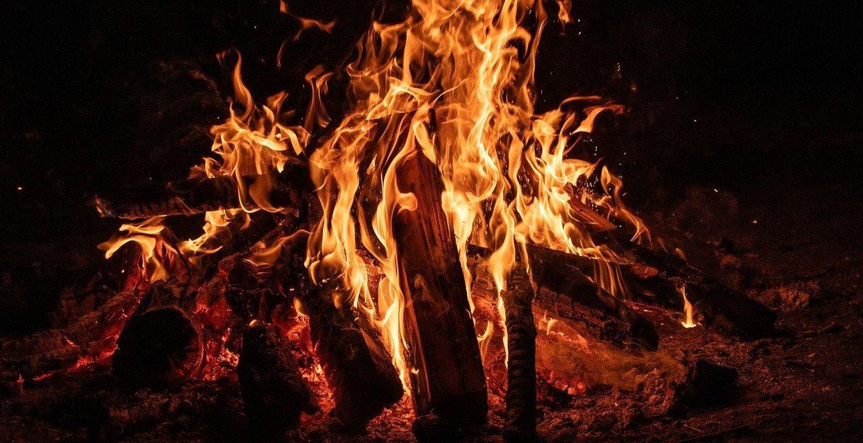 Ein loderndes Lagerfeuer in der Dunkelheit.