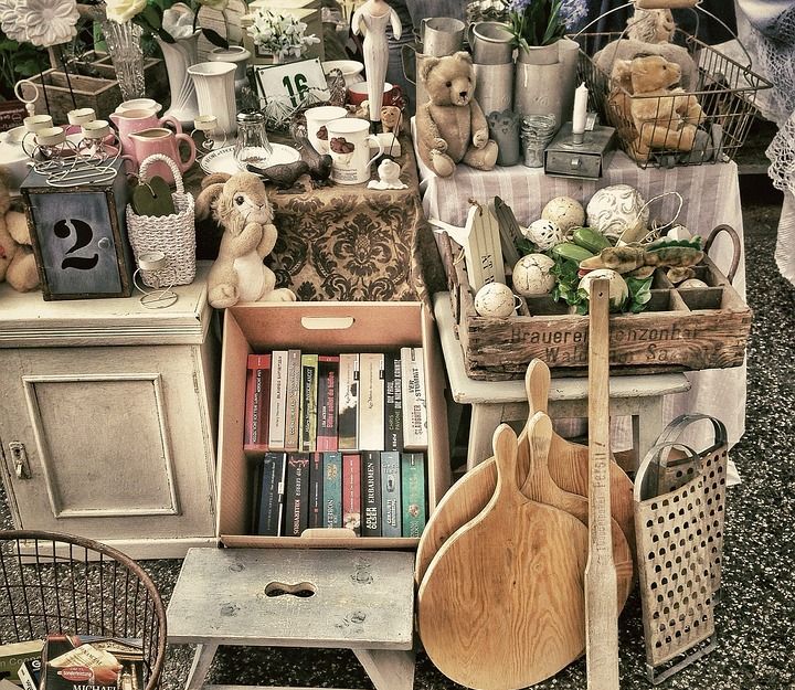 Flohmarktstand mit Büchern, Teddybären, Geschirr und Dekorationsartikeln.
