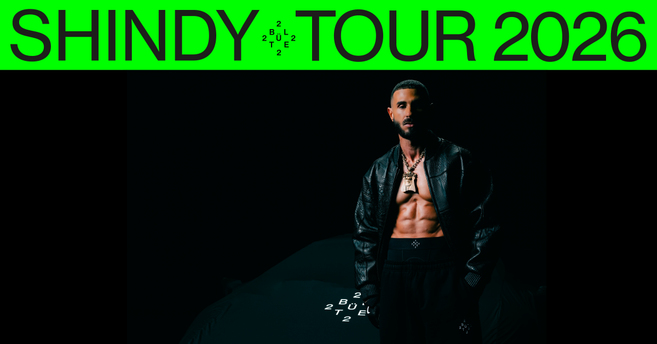 Ein muskulöser Mann in schwarzer Kleidung steht vor einem dunklen Hintergrund. Oben steht in grüner Schrift: 'SHINDY TOUR 2026'.