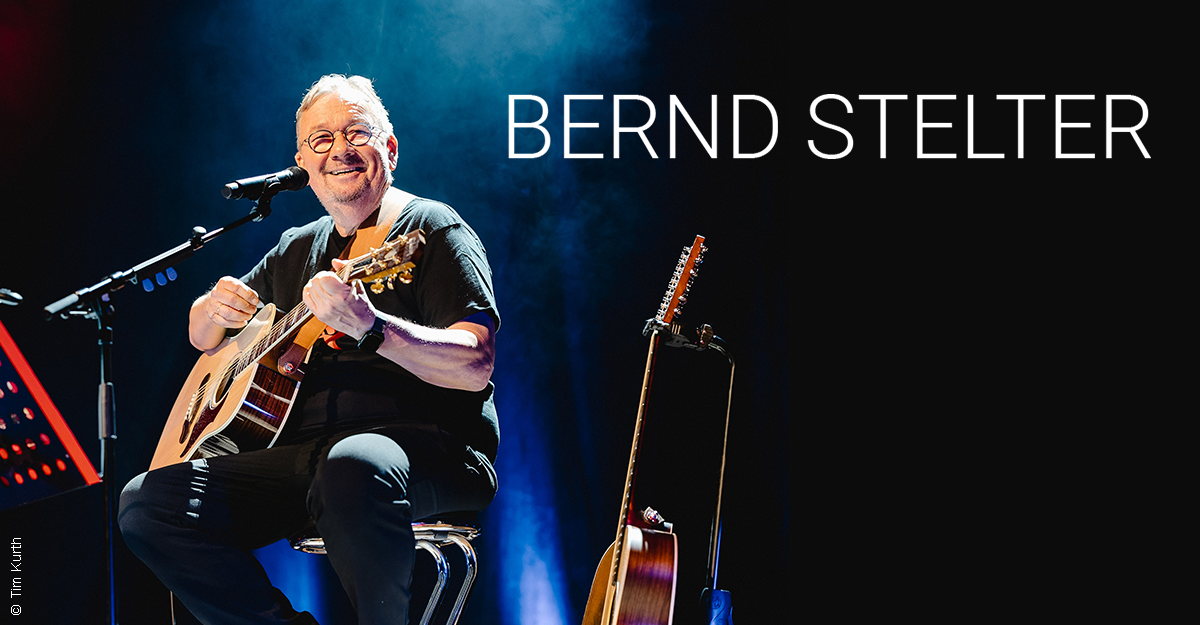 Bernd Stelter spielt Gitarre auf der Bühne.