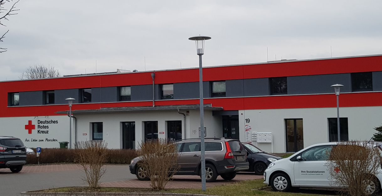 Gebäude des Deutschen Roten Kreuzes mit geparkten Autos davor.