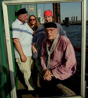 Vier Autorinnen in einem Bilderrahmen, dahinter Hamburger Hafen