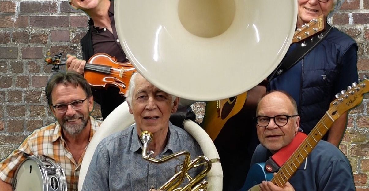 Eine Gruppe von fünf Musikern mit verschiedenen Instrumenten vor einer Backsteinmauer.