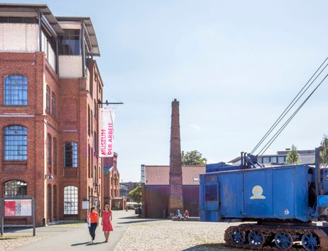 Außenansicht des Museums der Arbeit mit rotem Backsteingebäude und blauem Kran.