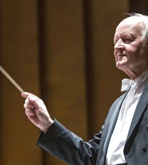 Ein Dirigent in Frack dirigiert mit einem Taktstock.