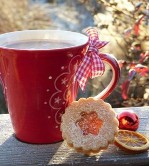 Rote winterliche Tasse mit einem Plätzchen