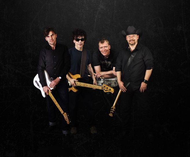 Vier Männer mit Musikinstrumenten vor schwarzem Hintergrund.