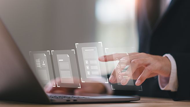 Es sind Hände zu sehen, die auf einem Laptop tippen