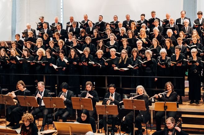 Ein Chor und ein Orchester führen gemeinsam ein Konzert auf.