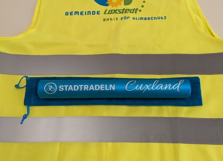 Eine gelbe Warnweste mit dem Logo der Gemeinde Loxstedt und einem blauen STADTRADELN-Schriftzug.