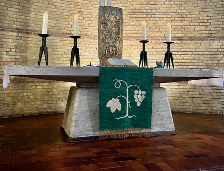 Altar in der Paul-Gerhardt-Kirche mit Kerzen und Abendmahlselementen.
