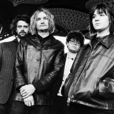 Schwarz-weiß-Foto von vier Personen in Lederjacken, die ernst in die Kamera schauen.