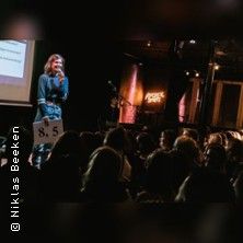 Person hält Vortrag bei Powerpoint Karaoke vor Publikum.