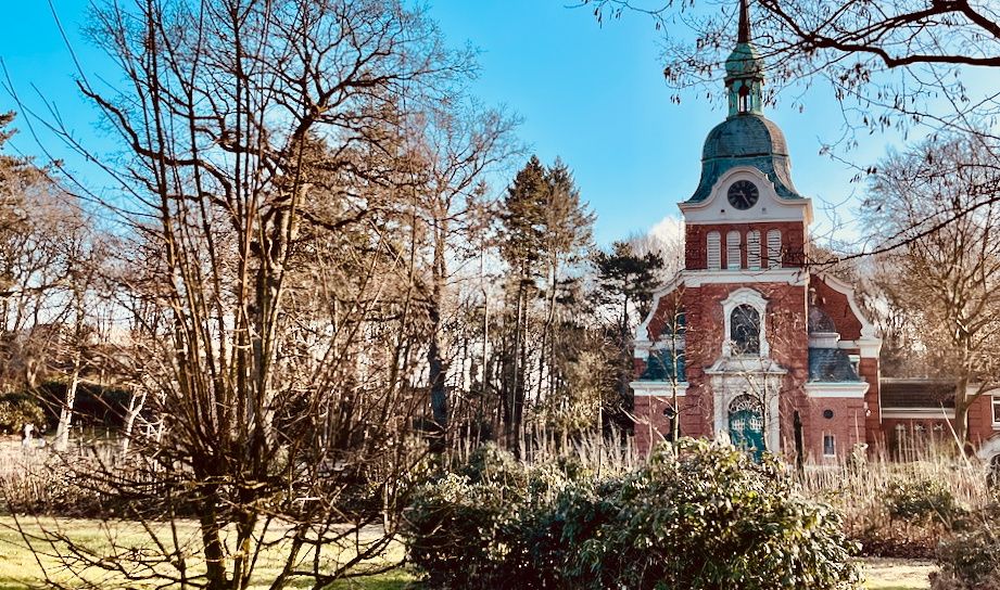 Lutherkirche im Frühjahr mit Bäumen im Vordergrund.