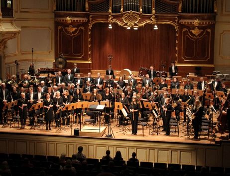 Ein symphonisches Blasorchester auf einer Bühne in einem Konzertsaal.