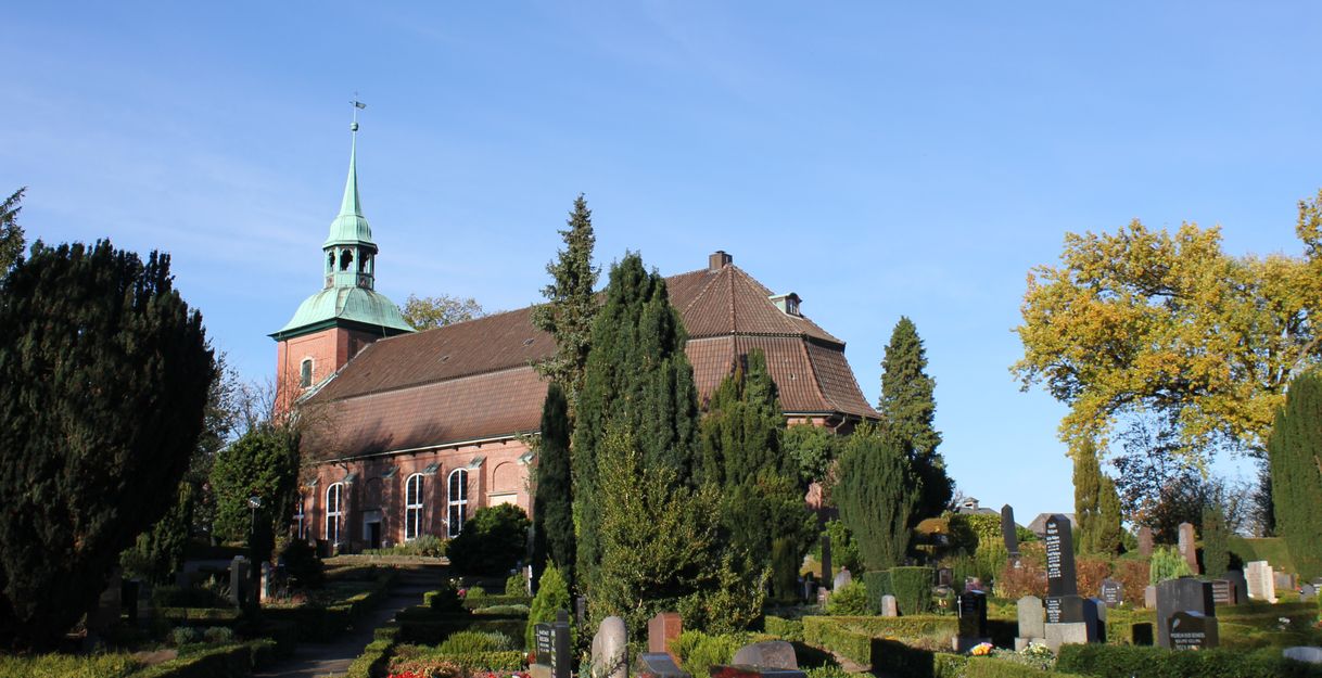 Kirche St. Pankratius in Ochsenwerder mit Friedhof im Vordergrund.