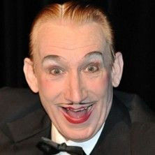 Ein Mann mit stark geschminktem Gesicht und fröhlichem Ausdruck.