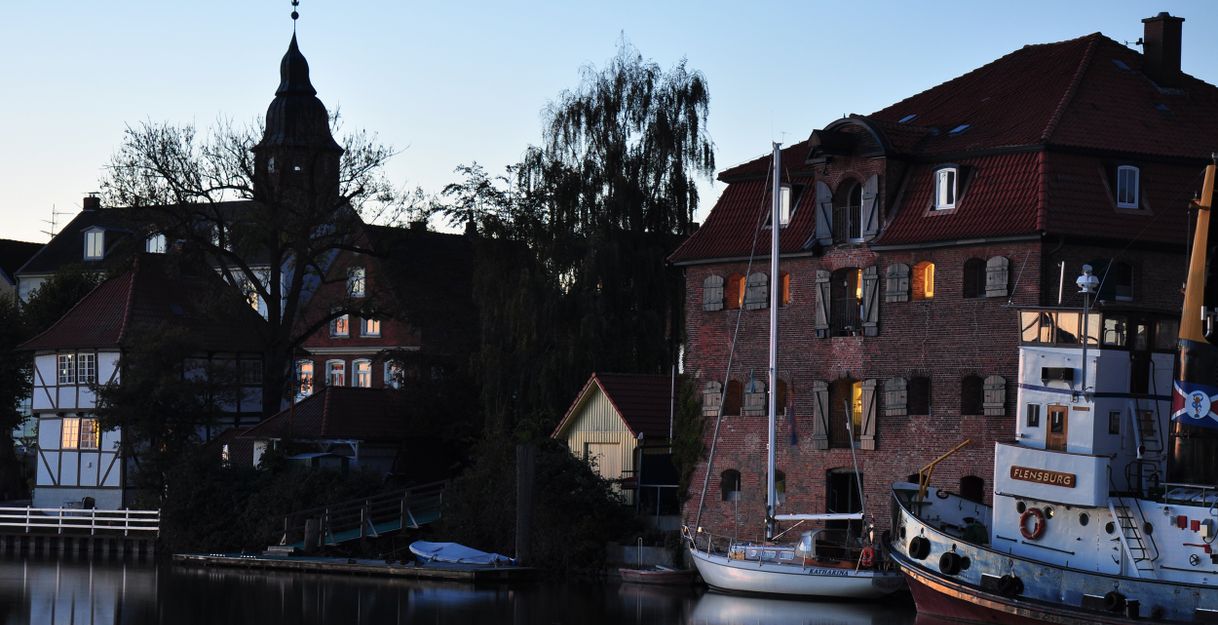Abendstimmung im Binnenhafen mit beleuchteten Gebäuden und Booten am Wasser.