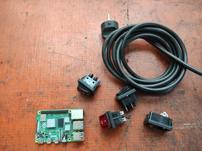 Stecker, Verlängerungsschnur und Platinen. Hintergrund ist rostorange.