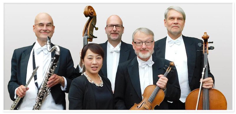 Fünf Mitglieder des Bremer Kaffeehaus Orchesters in formeller Kleidung mit Instrumenten.