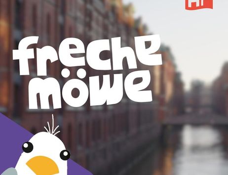 Illustration einer Möwe mit dem Text 'freche möwe' vor einem unscharfen Hintergrund einer Stadtansicht mit Wasserkanal.