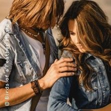 Ein Mann und eine Frau in Jeansjacken stehen eng beieinander.