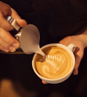 Barista zeichnet Kaffee Latte Art Figur