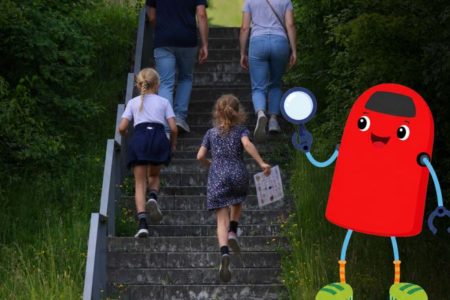 Zwei Erwachsene und zwei Kinder steigen die Treppe auf dem Energieberg hinauf.