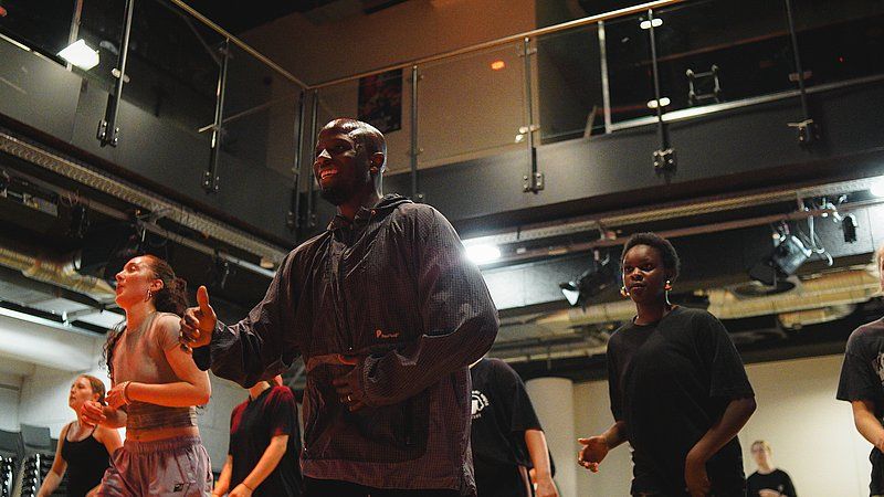 Menschen tanzen in einem Studio mit moderner Einrichtung.