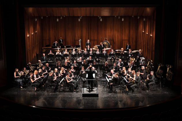 Ein Orchester spielt auf einer Bühne in einem Konzertsaal.