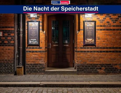 Eingang eines Gebäudes in der Speicherstadt bei Nacht, beleuchtet von Laternen.