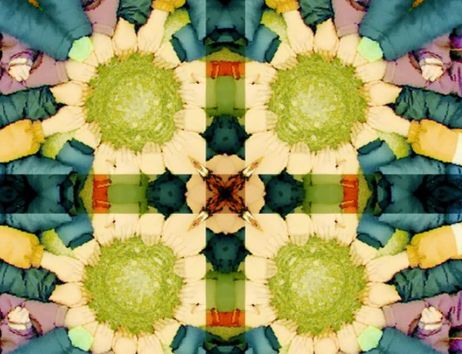 Ein kaleidoskopisches Bild mit bunten, symmetrisch angeordneten Formen und Farben, die an Blumen oder Mandalas erinnern.