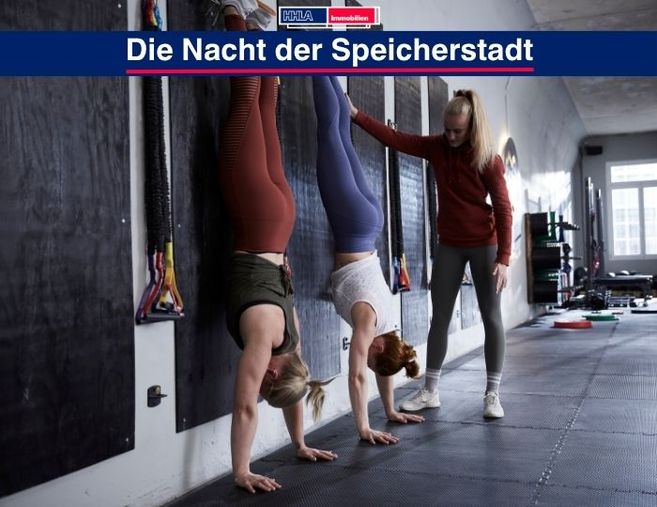Drei Personen machen Handstände an einer Wand in einem Fitnessstudio.